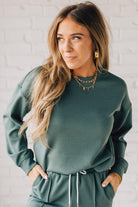 Blonde woman wearing a Soft Scuba Round-Neck Sweatshirt. Crafted from a soft, stretchy scuba fabric, this sweatshirt offers a relaxed fit with a classic round neckline, perfect for everyday wear and laid-back style.