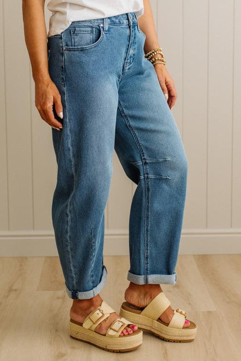 Person wearing blue jeans and beige sandals indoors.