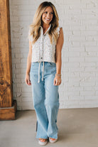 BLONDE WOMAN WEARING DRAWSTRING WAIST DETAIL STRETCH SIDE SLIT WIDE LEG JEAN IN MEDIUM BLUE.