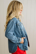 Woman wearing a denim jacket with a neutral background