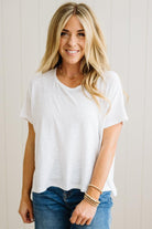 Woman wearing a white t-shirt and blue jeans with a neutral background