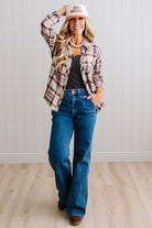 Blonde woman in a bright studio wearing dark jeans and a hat with a Taupe Oversized Flannel Shirt over a charcoal grey tank.