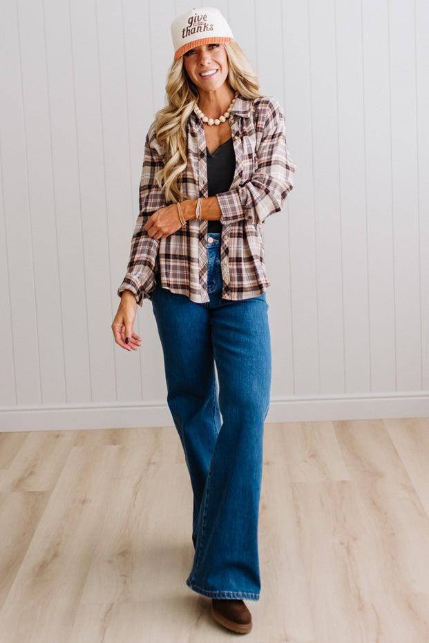 Blonde woman in a bright studio wearing dark jeans and a hat with a Taupe Oversized Flannel Shirt over a charcoal grey tank.