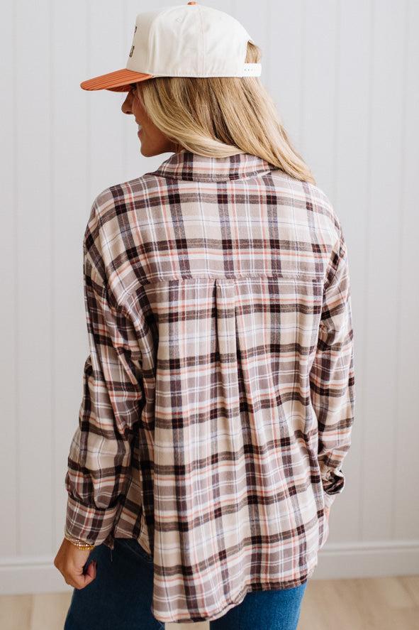 Blonde woman in a bright studio wearing dark jeans and a hat with a Taupe Oversized Flannel Shirt over a charcoal grey tank.