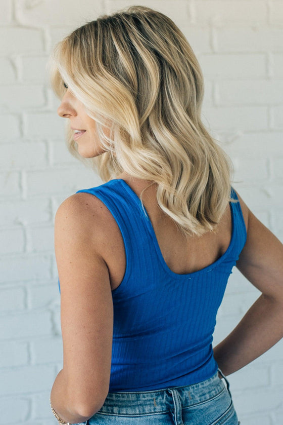 woman wearing a royal blue bodysuit that is soft ribbed material and a tank style strap.