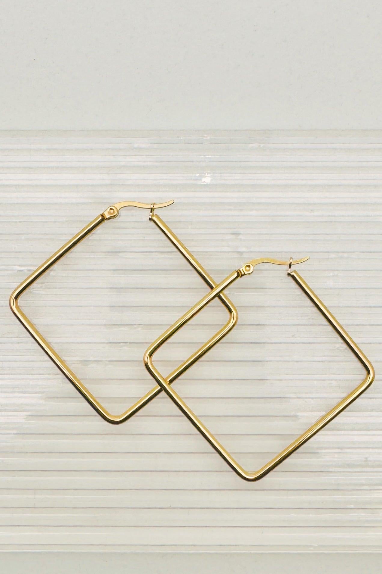 Gold hoop earrings on a light gray background