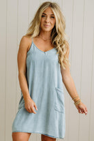 Woman wearing a light blue dress against a neutral background