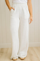 Person wearing white wide-leg pants against a neutral background