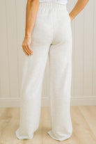 White linen pants worn by a person against a neutral background