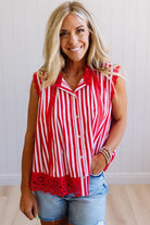 Woman wearing a red and white striped shirt with denim shorts indoors.
