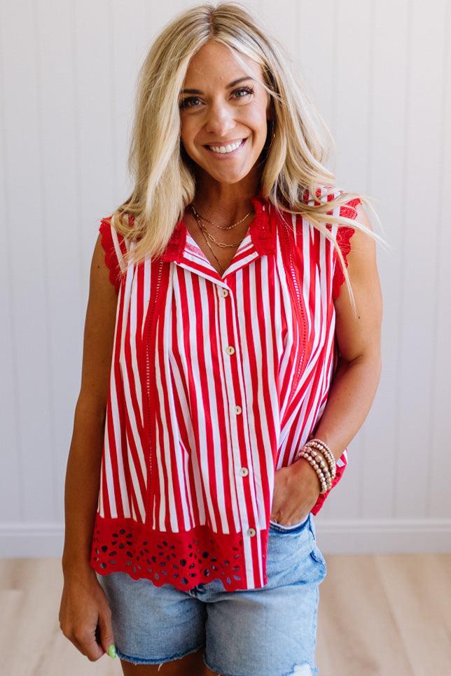 Woman wearing a red and white striped shirt with denim shorts indoors.