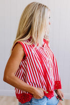 Woman wearing a red and white striped sleeveless top with a plain background