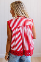 Person wearing a red and white striped sleeveless top with cut-out details on a plain background