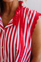 Red and white striped shirt with lace details on a neutral background