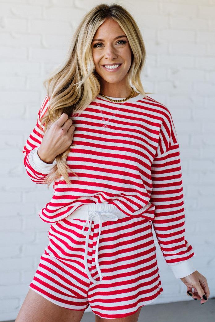 Woman wearing a red and white striped outfit against a white background