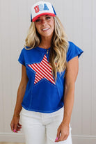 Woman wearing a blue top with an American flag design and a 'USA' cap.