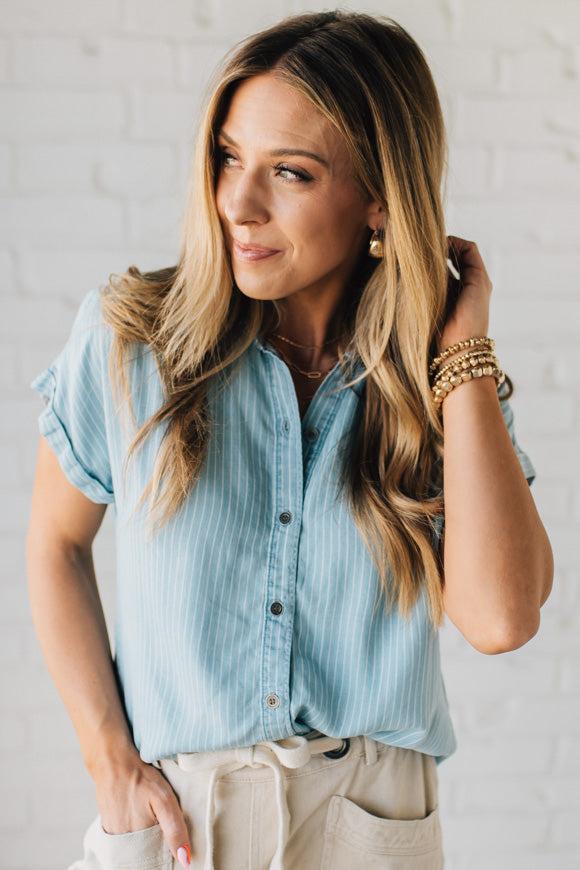 Blonde Woman Wearing a Striped Tencel Button Up Top W/ Rolled Sleeves.