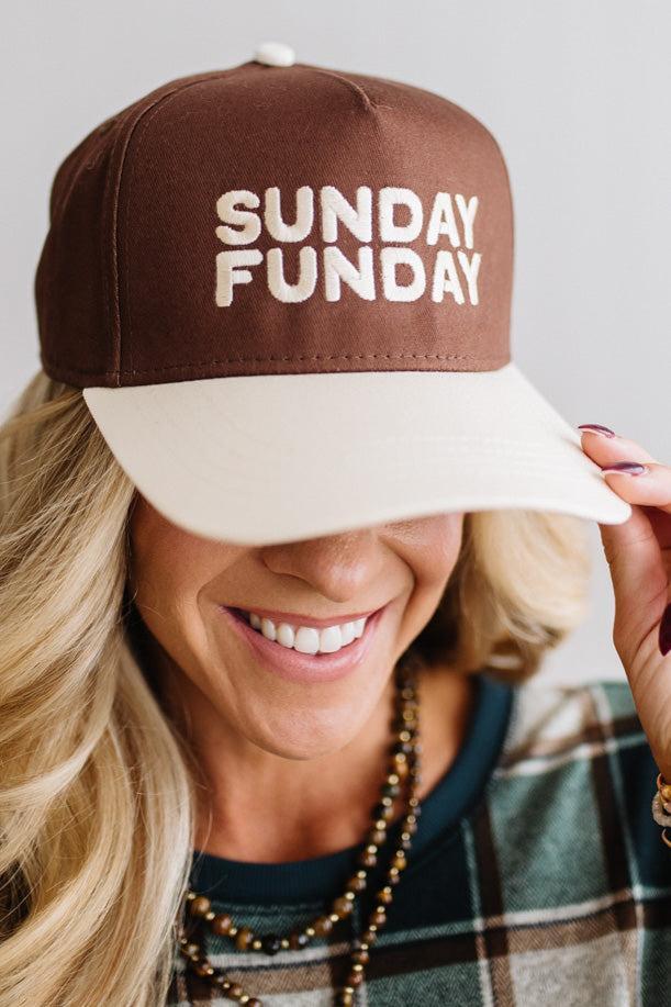Blonde woman in a plaid green top wearing a hat that is brown with a cream brim, and cream bold lettering embroidered saying: SUNDAY FUNDAY
