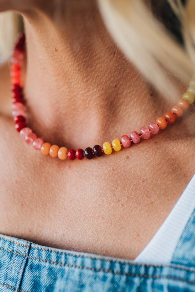 Necklace with multicolored beads worn by a person with a blurred background