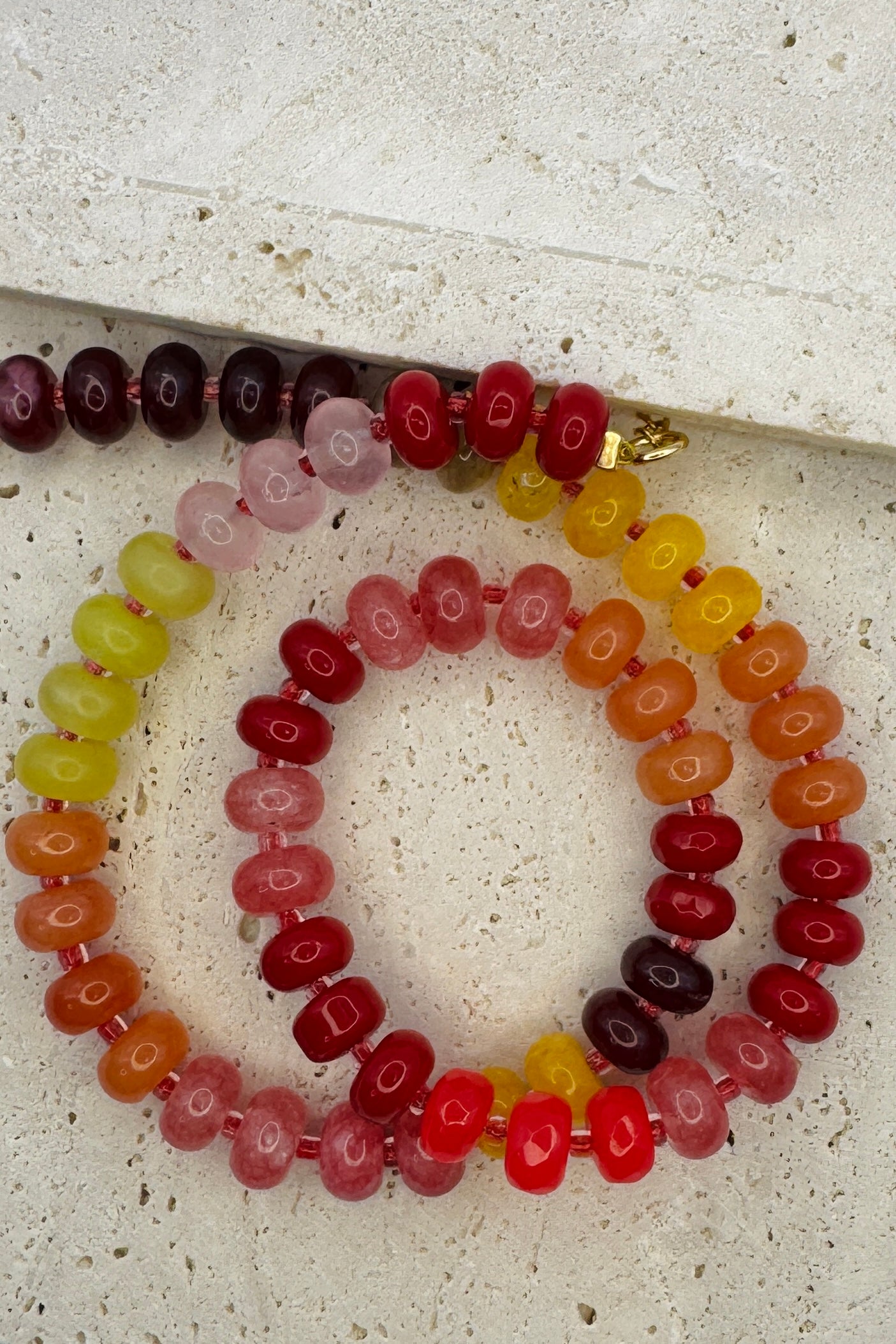 Set of colorful beaded bracelets on a textured surface