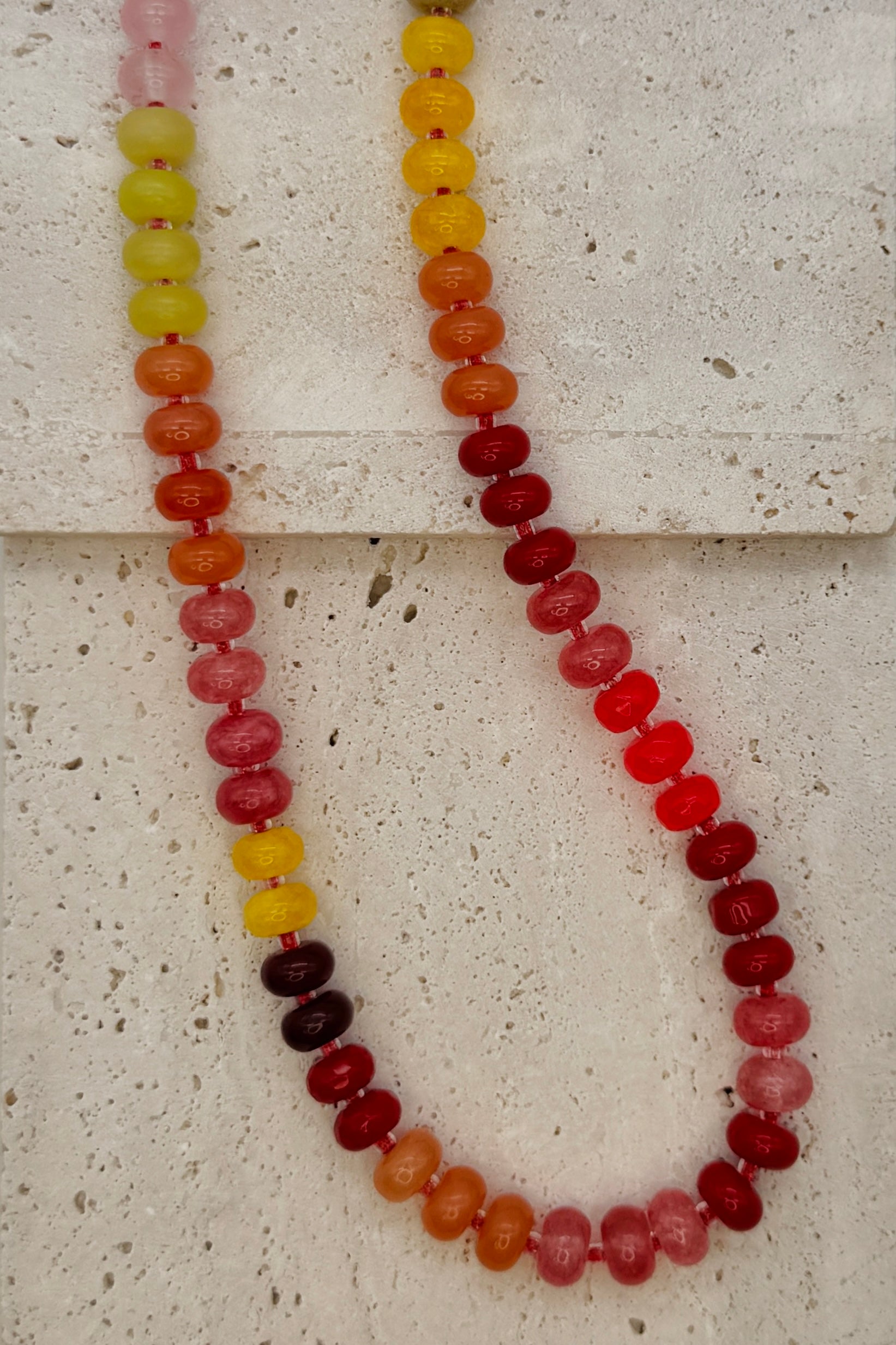 Necklace with multicolored beads on a textured surface