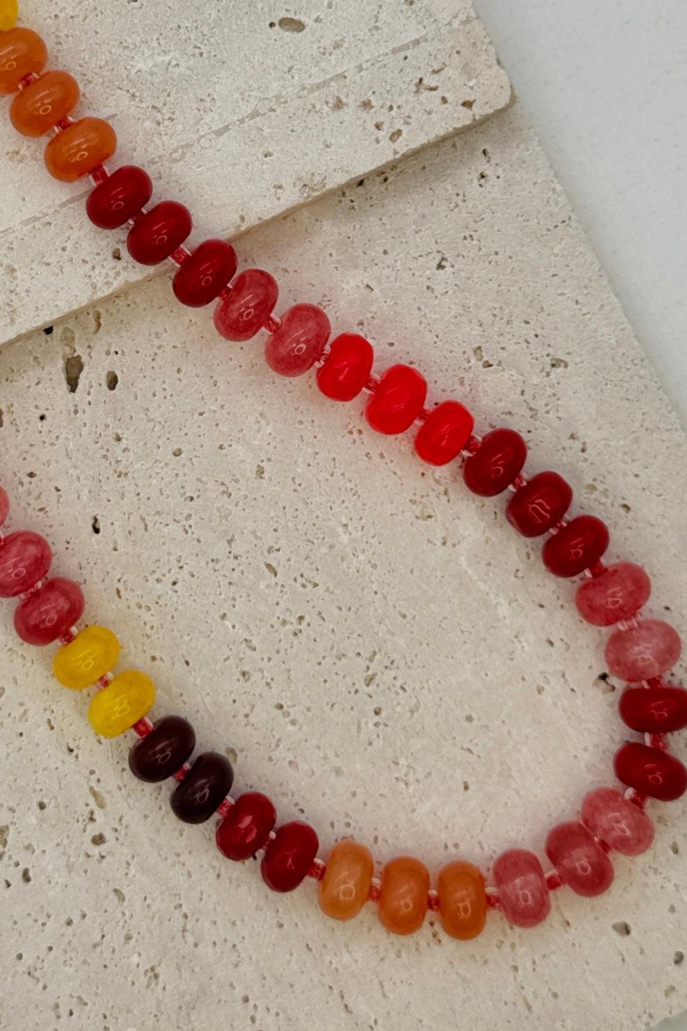 Necklace with multicolored beads on a textured surface
