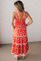 BLONDE WOMAN WEARING A RED FLORAL PRINT SLEEVELESS MAXI FEATURES: TIERED SKIRT PANEL WITH LACE INSET DETAIL, SMOCKED BACK, HIDDEN SIDE ZIPPER, THICK STRAPS WITH SCALLOPED LACE EDGES, SIDE POCKETS AND FULL LINING.