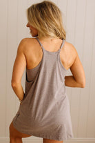 Woman wearing a brown tank dress against a neutral background