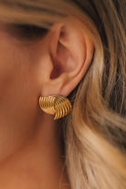 gold stud earings with an alternating swirl pattern