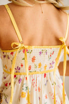 Yellow strap dress with floral pattern on a blurred background