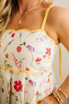 Floral dress with yellow trim worn by a person, with a neutral background