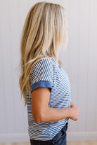 Person wearing a blue and white striped shirt against a plain background
