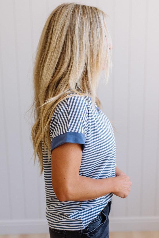 Person wearing a blue and white striped shirt against a plain background