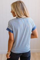 Woman wearing a blue and white striped shirt against a plain background