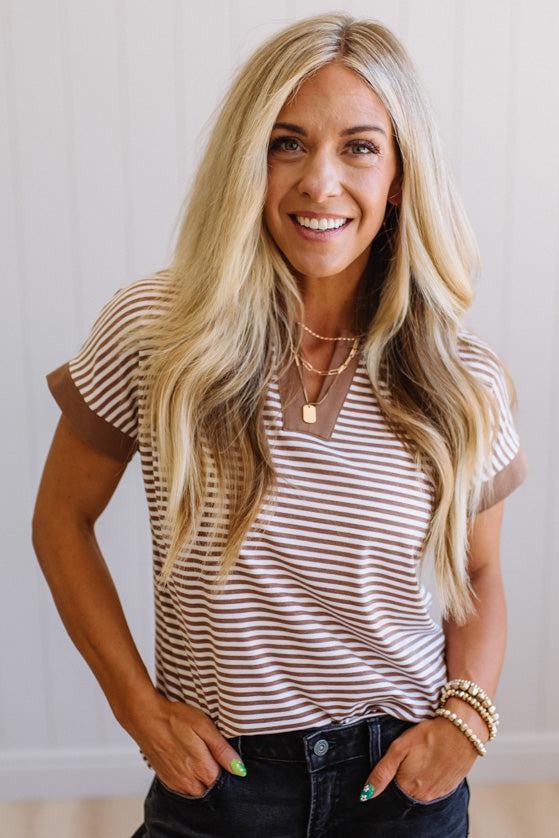 Woman wearing a striped shirt with a neutral background
