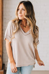 women modeling a creamy neutral short sleeve corded v neck top