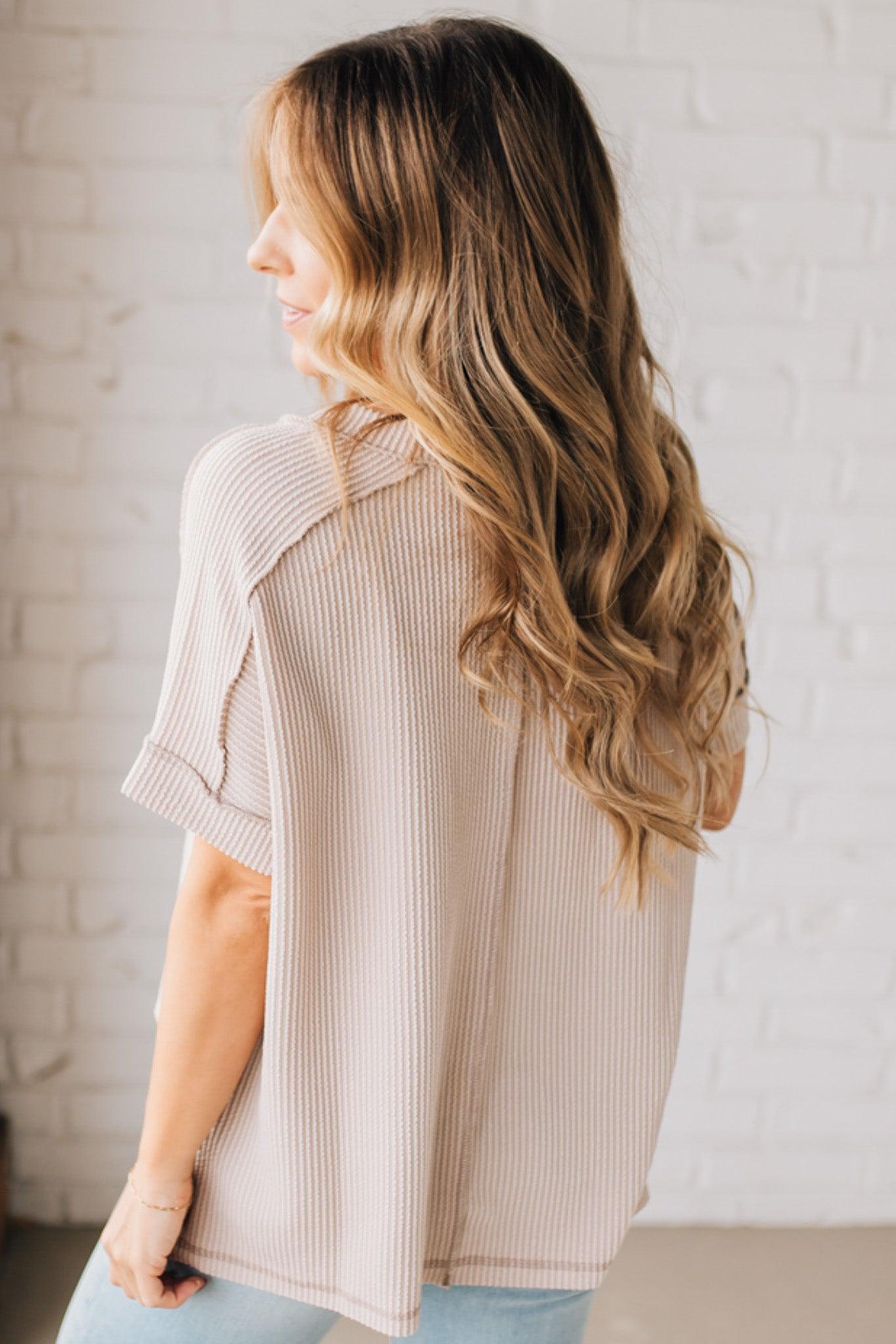 women modeling a creamy neutral short sleeve corded v neck top