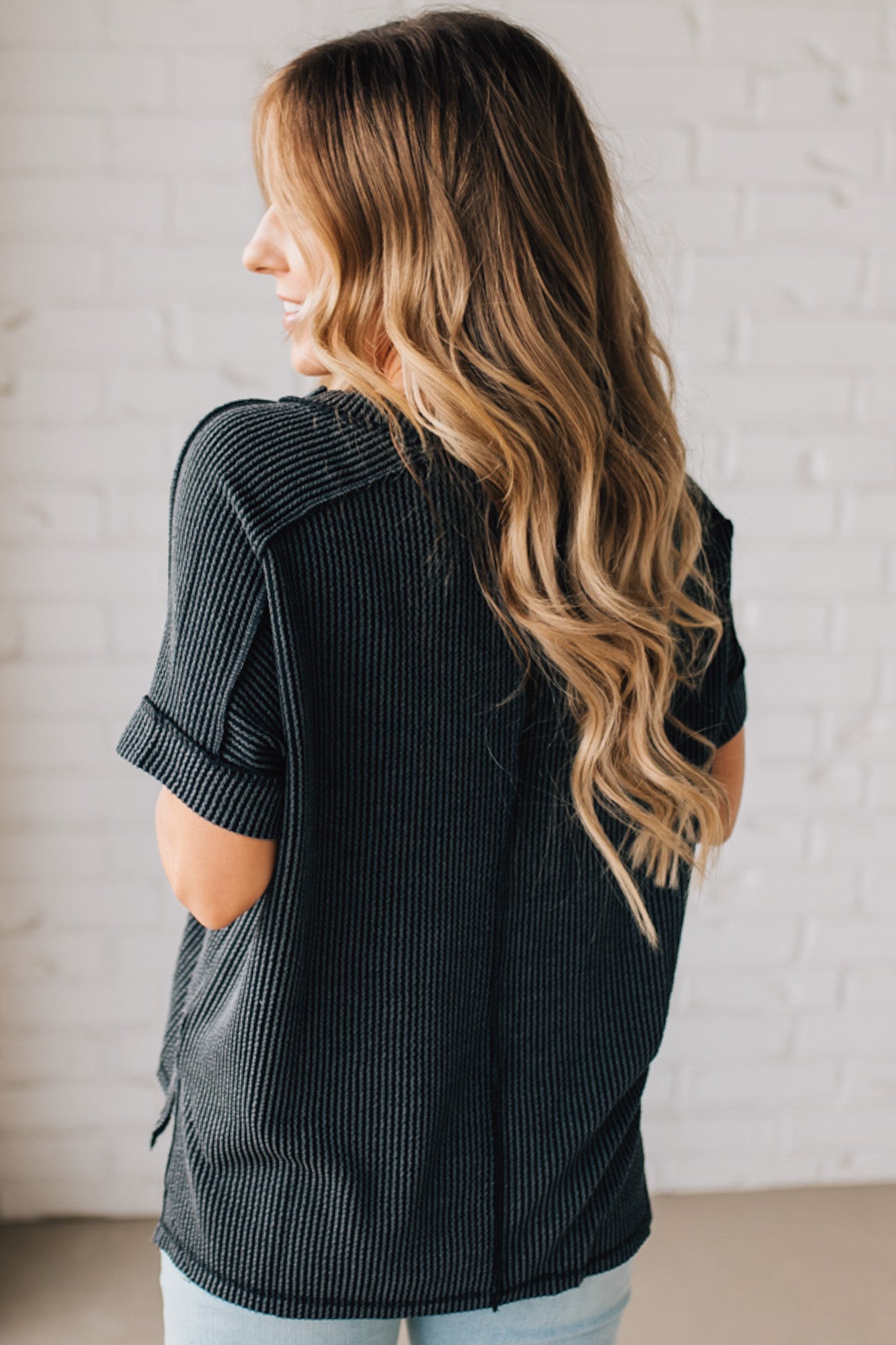 women modeling a black short sleeve corded v neck top