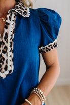 Blue top with leopard print details worn by a person