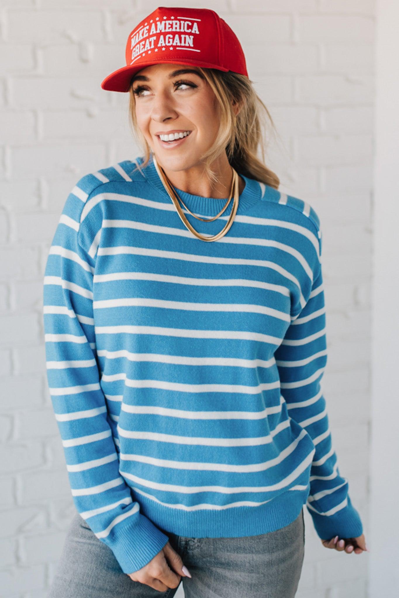 Blue and white striped crew neck sweater on blonde woman wearing a red hat.