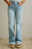 Light blue flared jeans worn by a person with a neutral background