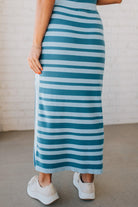 Blonde woman wearing a light blue and medium blue striped sweater ribbed maxi skirt with ribbed stretch waistband, and high side slit.