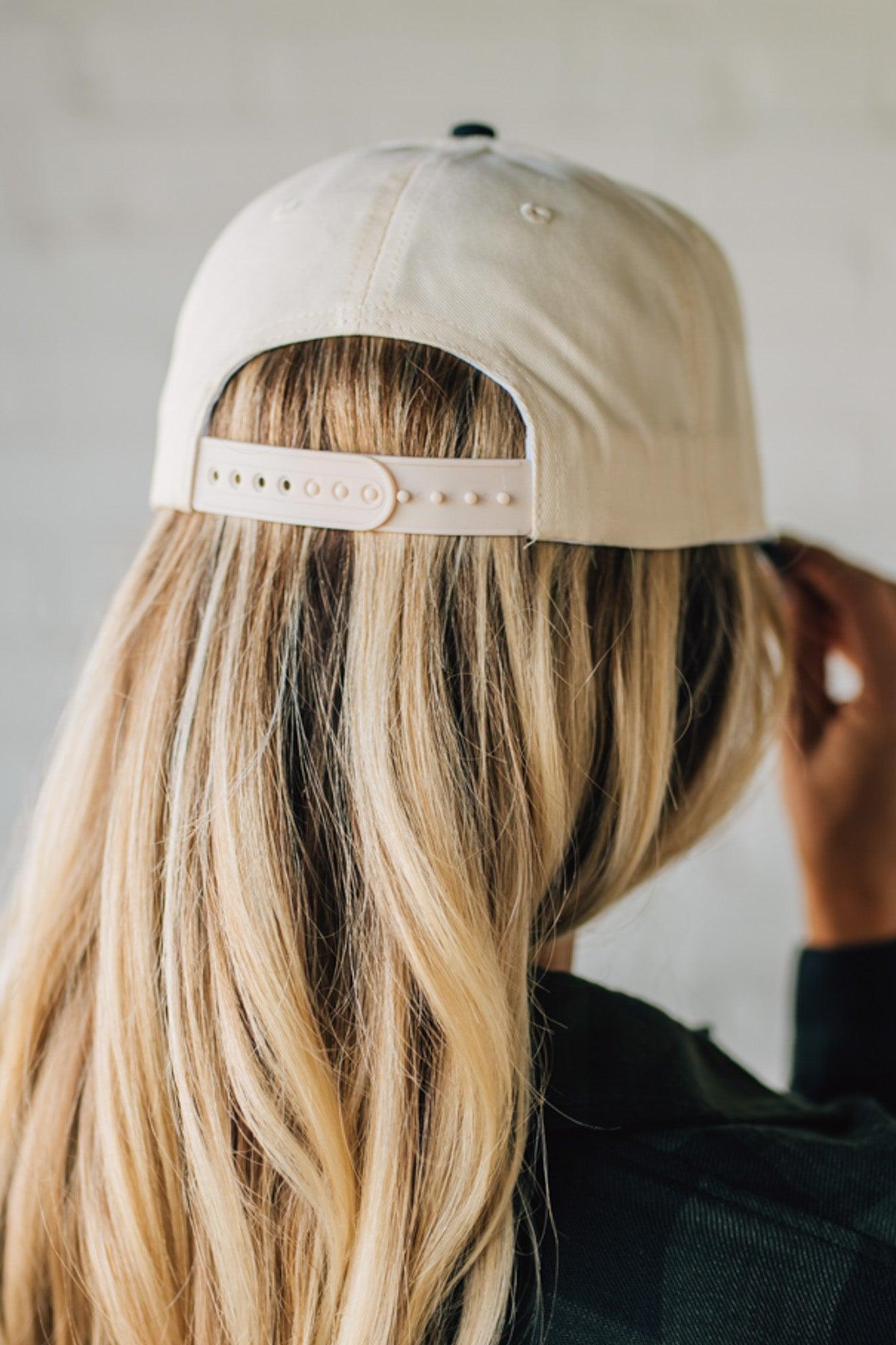 Person wearing a beige cap with a plain background