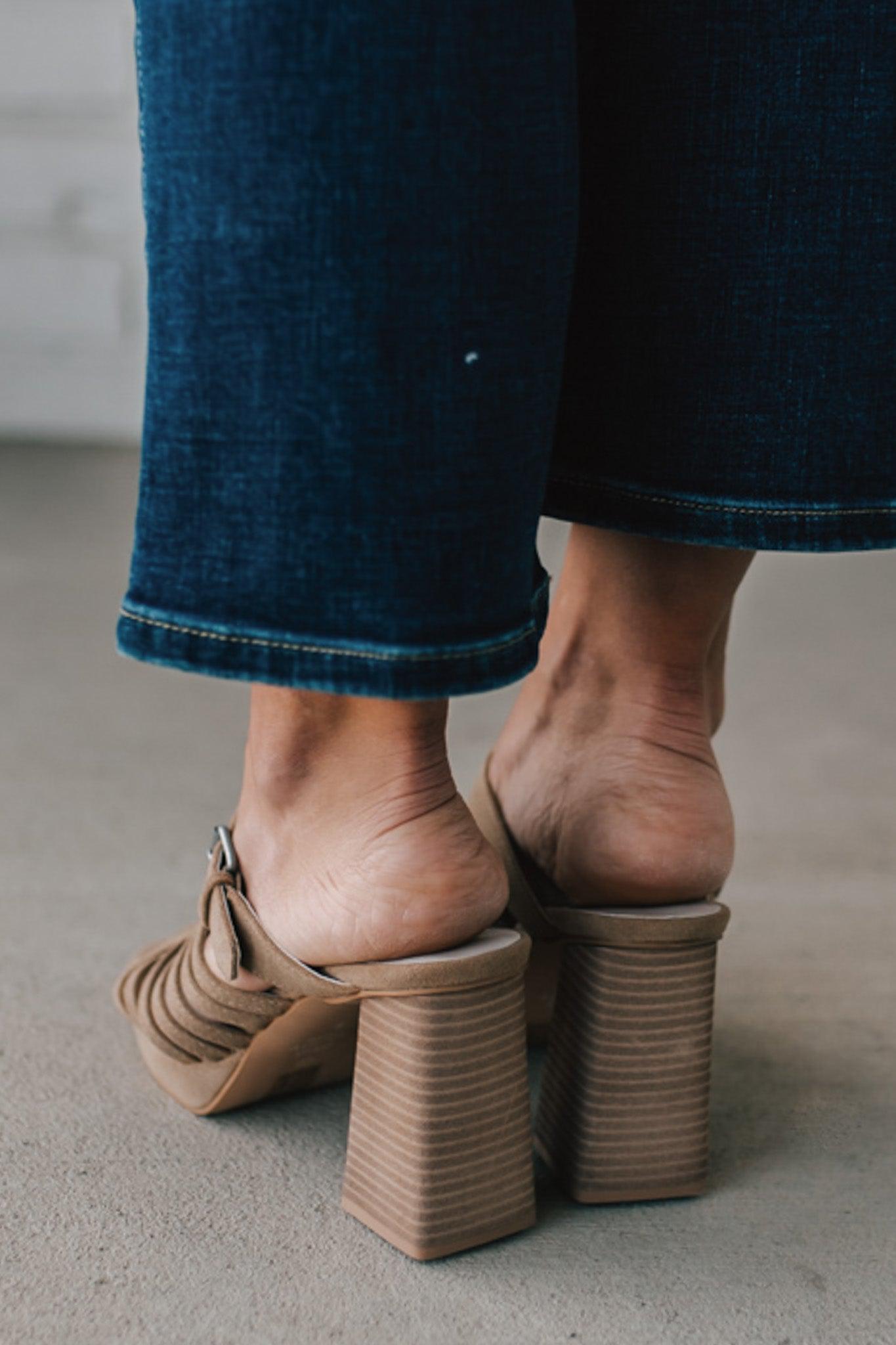 girl modeling an open toe basketweave heel in a neutral taupe color with silver buckle