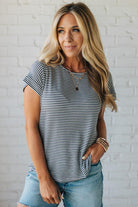 Blonde woman wearing a charcoal grey and white horizontal striped tee with a twist back keyhole accent across the back shoulders.