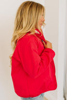 Woman wearing a red jacket against a plain background