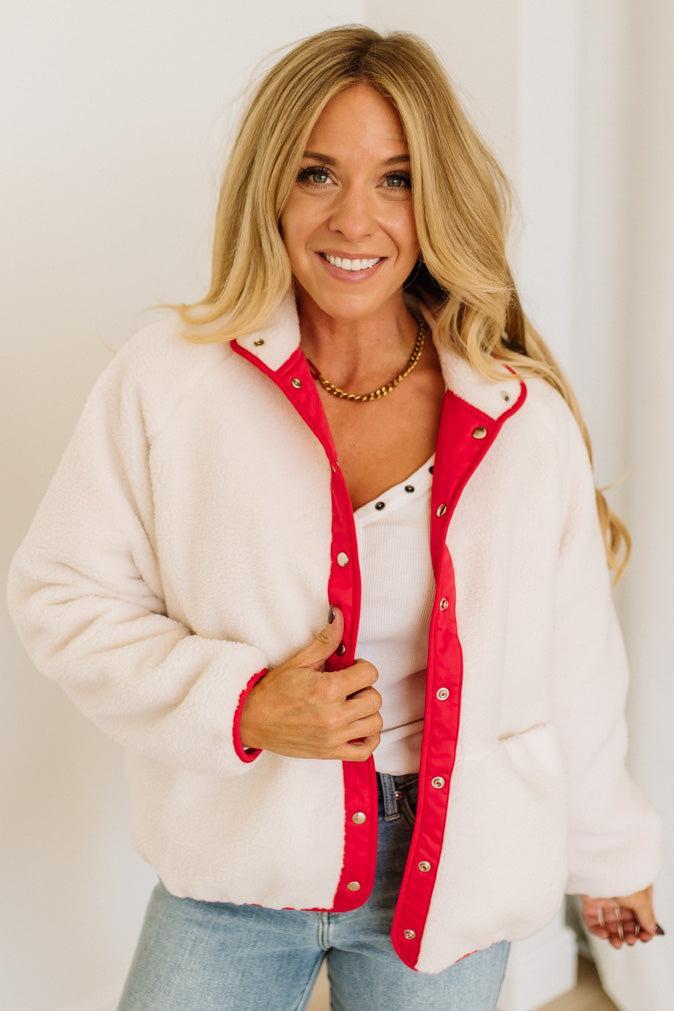 Woman wearing a white and red jacket with a plain background