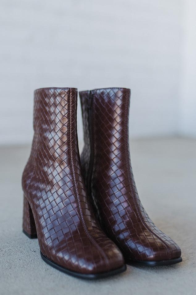 Pair of brown woven ankle boots on a light background