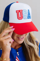 Person wearing a patriotic cap with 'USA' on a neutral background