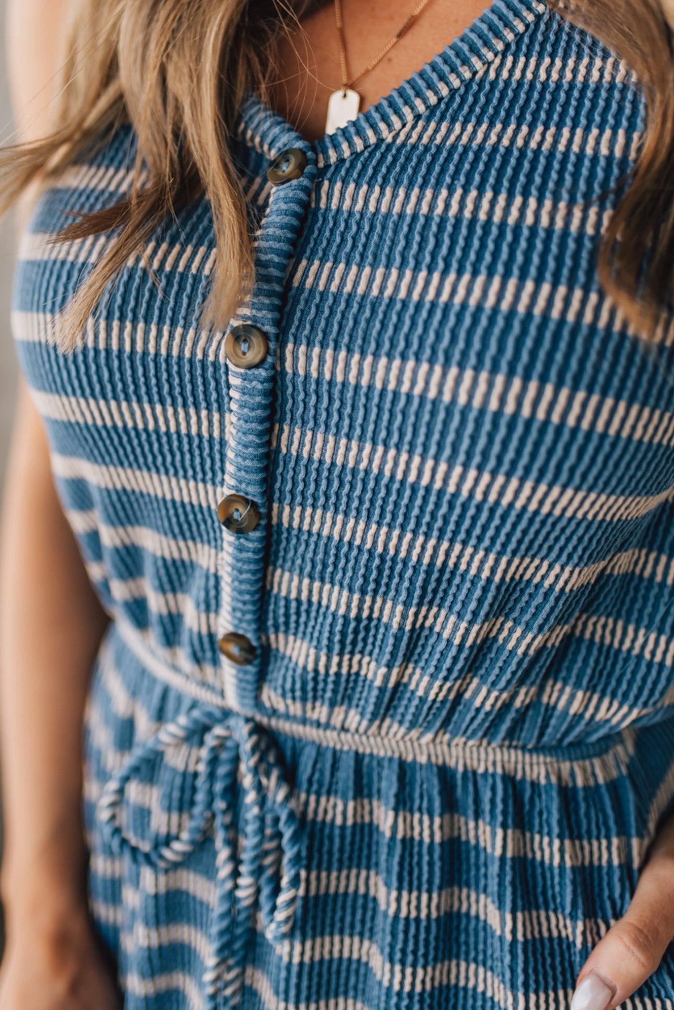 Blonde woman in a hat wearing a V-NECK, FAUX BUTTON UP, ELASTIC WAIST TIE, STRIPE DRESS WITH RIBBED TEXTURE knee length dress.